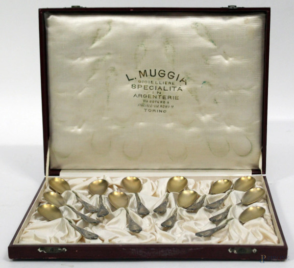 Lotto composto da dodici cucchiaini in argento cesellato, entro custodia.