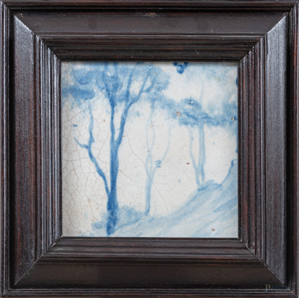 Mattonella in maiolica decorata nei toni del bianco e del blu con raffigurazione di alberi, XX secolo, cm 13x13, entro cornice, (segni di usura, difetti di cottura, felature, difetti)