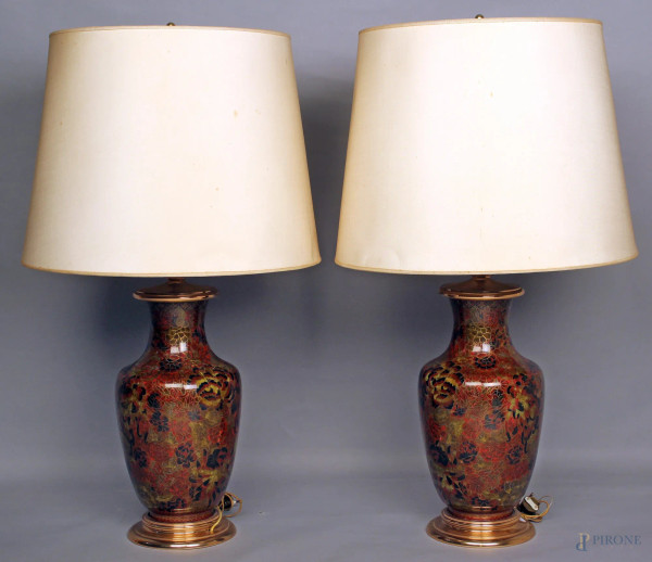Coppia di lampade in porcellana smaltata a decori floreali, base e finale in ottone, complete di paralumi, H 70 cm.