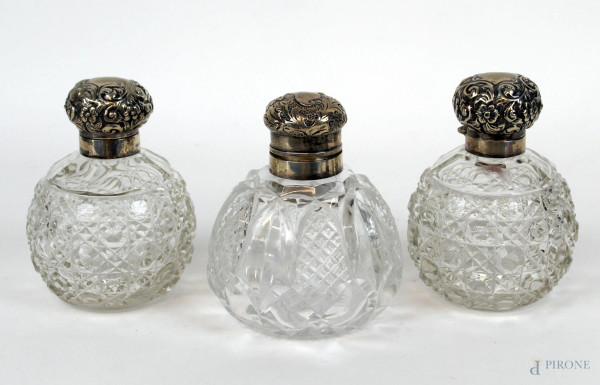 Lotto di tre bottigliette portaprofumo in cristallo controtagliato, tappi in argento, cm h 12, inizi XX secolo.