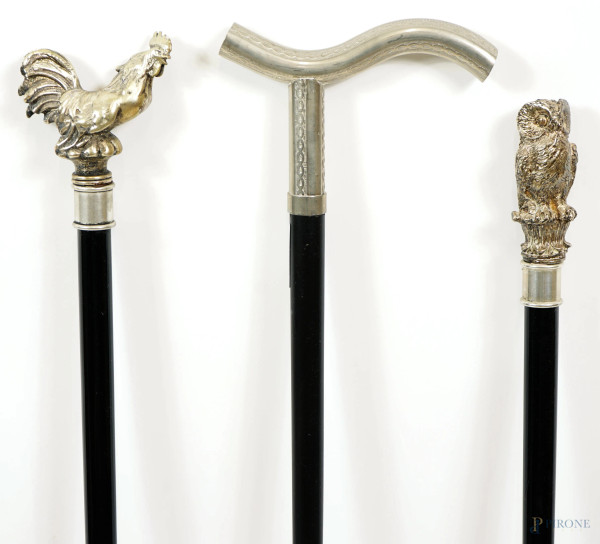 Lotto di tre bastoni da passeggio in legno laccato nero con manico in metallo argentato e resina,...