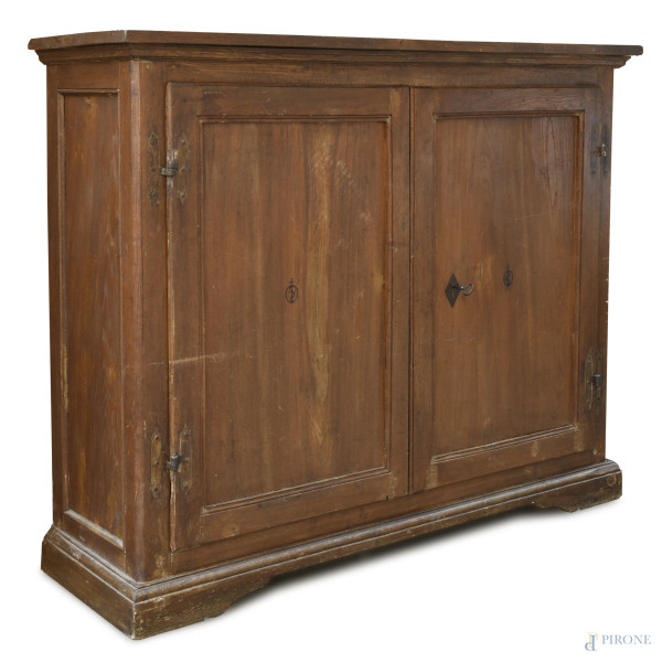 Credenza in noce a doppia anta e interno a triplice ripiano, fine XVIII secolo, cm 131,5x162x49, ...