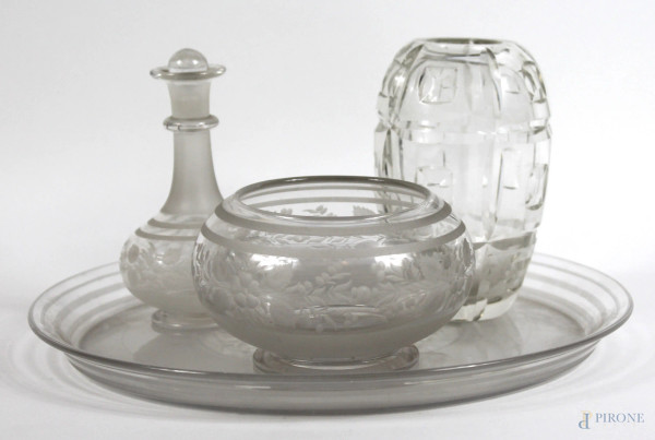 Lotto di quattro oggetti in vetro controtagliato, composto da un piatto, un centrotavola, un vasetto ed un&#39;ampolla, altezza max cm.12, diametro piatto cm. 26.