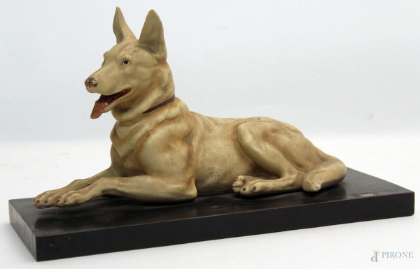 Maiolica dipinta, raffigurante cane, poggiante su base in legno, H. 17x28 cm., (piccoli difetti).