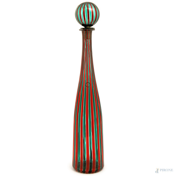 Bottiglia in vetro di Murano della serie "Morandiana" di Venini a canne nei toni del rosso e del verde, firmato e datato a graffio sotto la base "Venini Italia 85", altezza cm 48 (difetti, rotture e riparazioni al tappo che risulta incollato alla bottiglia)