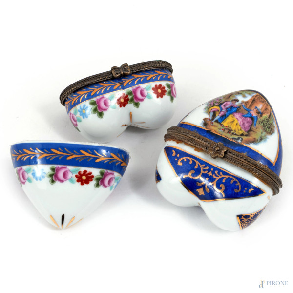 Lotto di due scatoline a forma di cuore in porcellana smaltata nei toni del blu e dell'oro, decorate a motivi floreali e scene di genere, XX secolo, misure massime cm 8x6,5x3,5, (segni di usura, difetti, rotture)