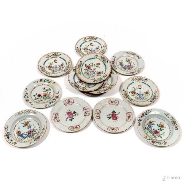 Lotto di 14 piatti di varia foggia in porcellana decorata in policromia a motivi vegetali e paesaggistici, misura massima diametro cm 23 Cina, XX secolo, (difetti)