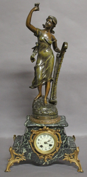 Pendola francese in marmo verde con quadrante smaltato, sormontato da figura con arpa e poggiante su quattro piedini in bronzo dorato, H 68 cm, da revisionare.