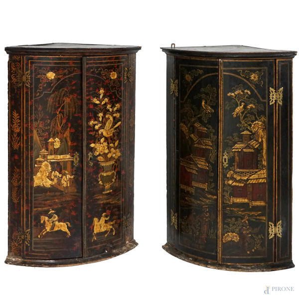 Coppia di angoliere in legno laccato nero dipinto in rosso e oro a raffigurare paesaggi con figure orientali e vasi di fiori con volatili, prospetto bombato a due ante. Cina, XIX secolo, cm 92x60x40 (difetti)