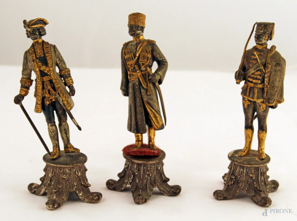 Lotto di tre personaggi in piombo e metallo inciso e dorato, h. 15 cm