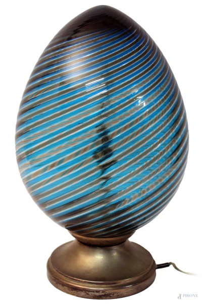 Lume da tavola a forma di uovo in vetro colorato a torchon, fondo blu, poggiante su base in metallo, H 38 cm, firmato Venini.