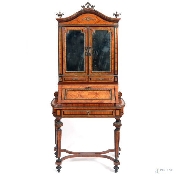 Mobile scrittoio in legno impiallacciato in varie essenze con piano a ribalta celante cassetti e sormontato da alzata superiore a doppia anta specchiata, gambe rastremate tornite e raccordate da traversa sagomata a crociera, XIX secolo, cm 187x87x44, (segni di usura, scalfiture, difetti)