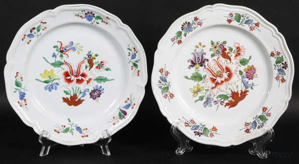 Coppia di piatti in porcellana dipinta a decoro di fiori, bordo mistilineo e centinato, diametro 23 cm, XX secolo.