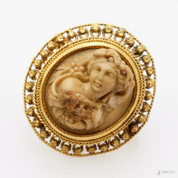 Spilla in filigrana in oro 14 Kt con cammeo in pietra lavica rappresentante una figura femminile, cm 2,6x2,4, peso gr. 5.3, (difetti)