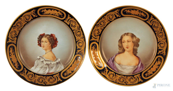 Coppia di piatti in porcellana con medaglioni centrali dipinti a decoro di busti di donne, fascia blu cobalto e oro, marcata Maissen, diam. 25 cm.