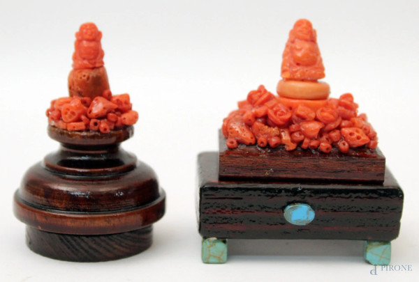 Lotto composto da due Budda in corallo, poggianti su basi in tek, H 7 cm.