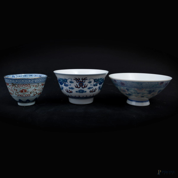 Lotto di tre tazzine in porcellana a decori blu su fondo bianco, Cina XX Secolo, misura massima cm  5,5x12, (lievi segni di usura)