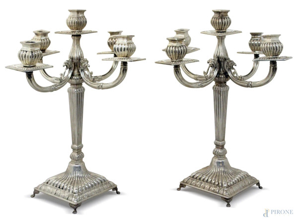 Coppia di candelieri a quattro luci in argento poggiante su quattro piedini, gr. 2050, h. 38 cm.