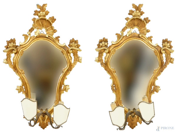 Coppia di appliques a due luci in legno scolpito e dorato, metà XX secolo, due braccia a volute in ferro battuto, cm 68x42, (difetti)