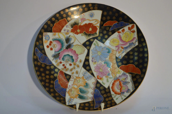 Lotto di due antichi piatti in maiolica a decori policromi, arte orientale, (un restauro), diam. 35/46 cm.