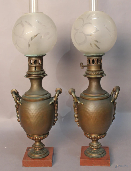 Coppia di lumi a petrolio in bronzo con globi in vetro, basi in marmo, XIX sec., H 75 cm.