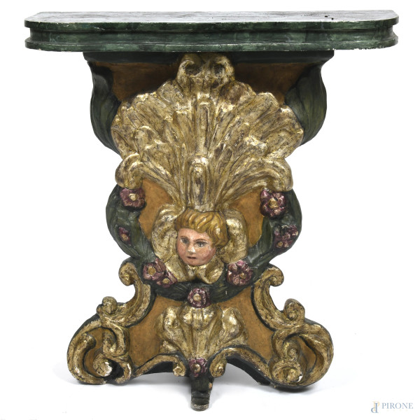 Consolle in legno dipinto e dorato con piano sagomato e fusto intagliato a volute vegetali e floreali con testa di putto, XX secolo, cm 91x81x30, (segni di usura, difetti, scalfiture, fessurazioni)