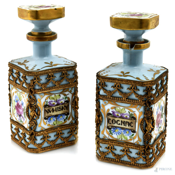Servizio composto da due bottiglie in porcellana Sevres decorata a motivi floreali policromi con fondo oro e azzurro con inserti in metallo dorato, XX secolo, altezza cm 23, (segni di usura, sbeccature, rotture, cadute di smalto)