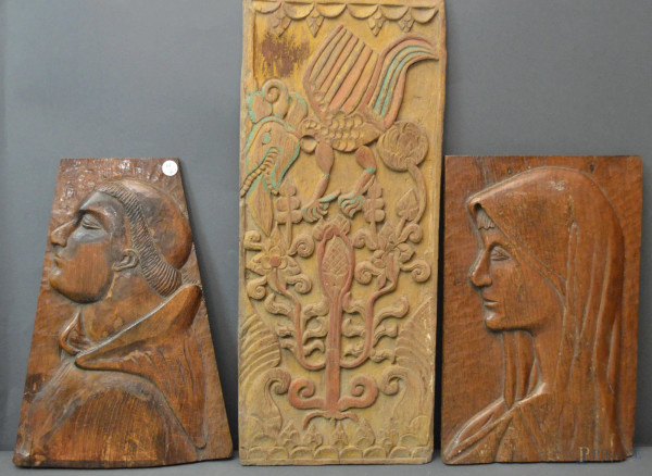 Lotto di tre pannelli in legno intaglio a soggetti diversi.
