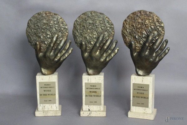 Lotto composto da tre premi internazionali, Work in the world, al Maestro Rolando Nicolisi, 1989, a forma di mano con globo, H 40 cm.