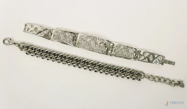 Lotto di due bracciali in metallo argentato con strass, di cui uno semirigido, lunghezza max cm 24, (mancanti alcuni strass).