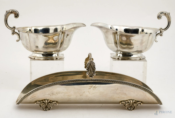 Lotto composto da portagrissini in argento 800/000 cesellato con presa a foggia di ramo fogliato poggiante su quattro piedini e due salsiere in agento 800/000 con presa a voluta, peso complessivo 610, misura massima cm 10,5x27x9,5