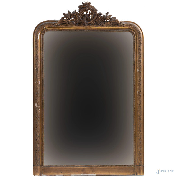 Specchiera in legno intagliato e dorato con elemento apicale decorato a volute e festoni, XX secolo, cm 153,5x97, (segni di usura, perdita di doratura, rotture, mancanze, restauri, difetti)