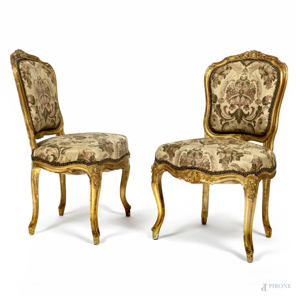 Coppia di poltrone con struttura in legno intagliato e dorato, con schienale e seduta imbottiti e rivestiti in tessuto a motivi floreali e vegetali, XX secolo, cm 89x50x50, (segni di usura, scalfiture, fori di tarlo, restauri, difetti)
