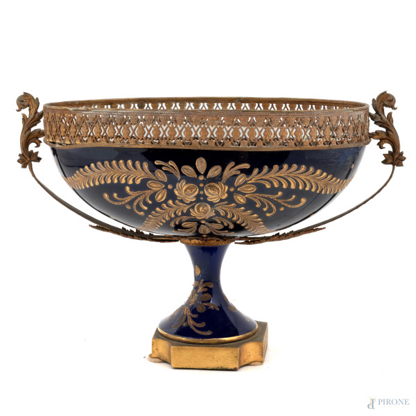 Coppa in porcellana decorata nei toni del blu e dell'oro a motivi floreali con inserti in bronzo dorato, XX secolo, cm 20x29x15, (segni di usura, difetti)