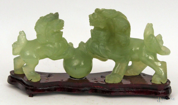 Cani di fo, scultura in giada, poggiante su base di tek, h. cm 10, lung. cm 23.