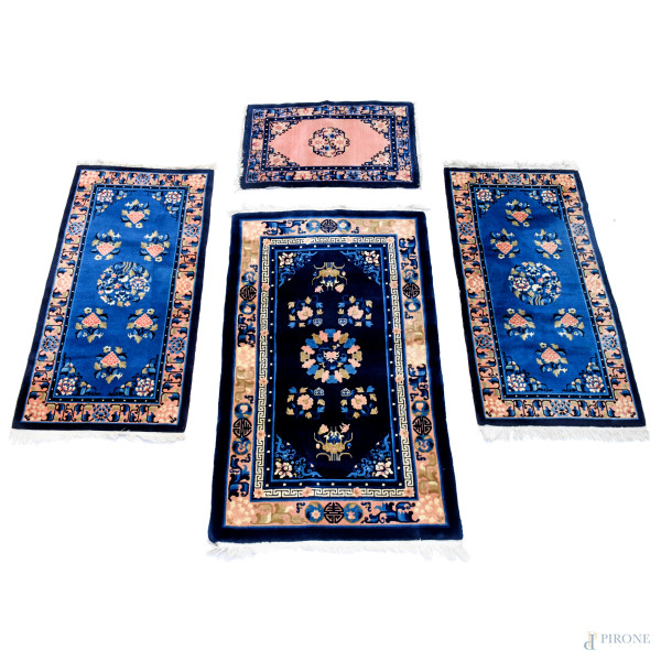 Lotto di quattro tappeti, cm 70x144; cm 92,5x159; cm 61x94; cm 71x147, (difetti)