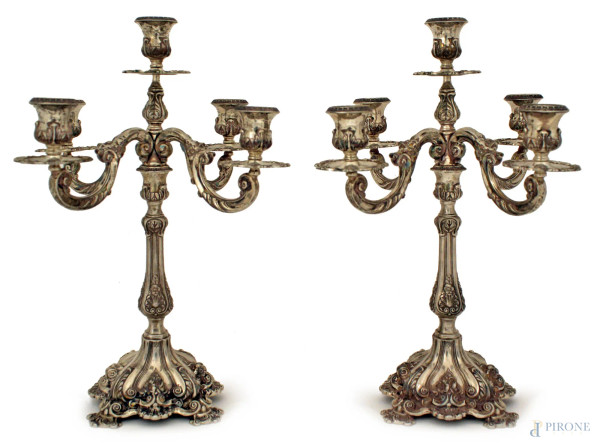 Coppia di candelieri a cinque luci in argento cesellato, H. 37 cm, gr. 2050.