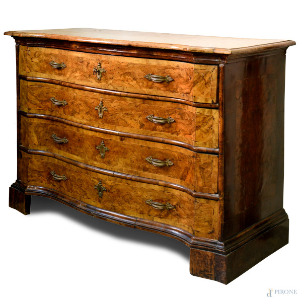 Cassettone in legno di varie essenze a fronte e profilo mosso. Quattro cassetti al fronte con maniglie e boccachiave in bronzo. XVIII secolo, cm 108x146x95 (difetti e parti sostituite)