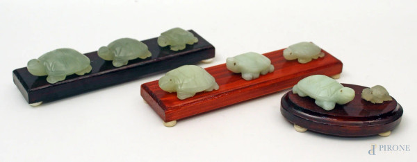 Lotto composto da otto sculture a soggetto di tartarughe in giada, poggianti su tre basi in legno, Lunghezza massima 18 cm.
