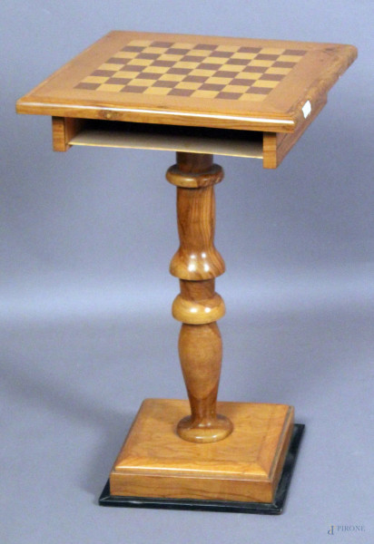 Tavolinetto a scacchiera in ulivo, poggiante su colonna e base, (mancante cassetta), h. 67x40x40 cm.