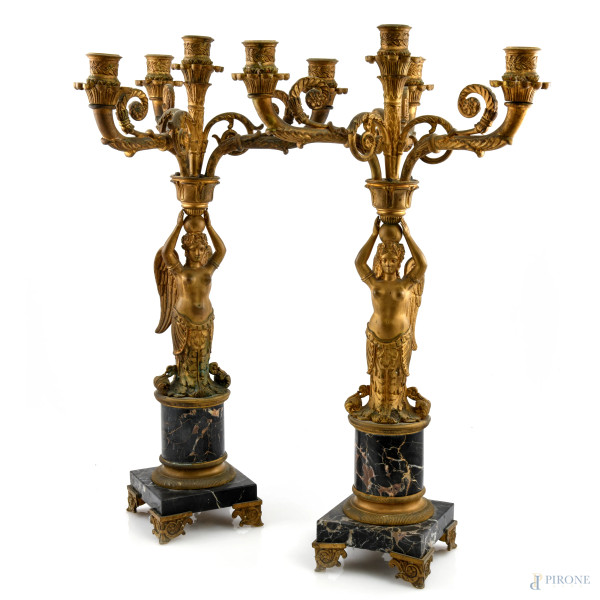 Lotto di due candelabri in bronzo dorato e marmo a quattro luci con fusti a foggia di figure femminili alate, XIX secolo, altezza cm 53,5, (segni di usura, scalfiture, difetti)
