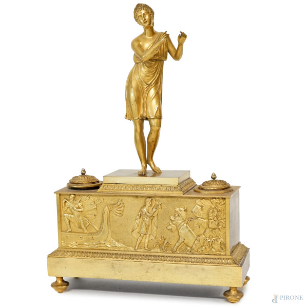 Calamaio  in bronzo dorato, XIX secolo, sormontato da fanciulla con veste alla greca, base rettangolare con decori a rilievo raffiguranti Eracle contro Cerbero, ingombro cm h  39x26,5x9, (difetti e mancanze).