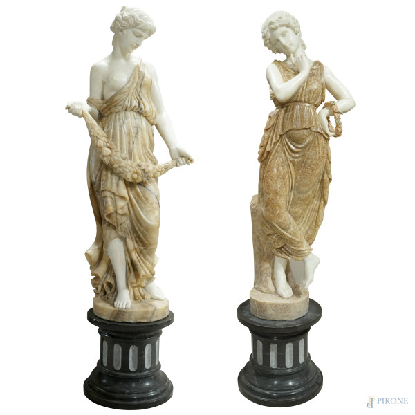 Coppia di sculture in marmo e alabastro rappresentanti due figure allegoriche femminili, basi in marmo nero, XX secolo, altezza cm 144 e cm 153, base cm 40,5, (difetti e restauri)