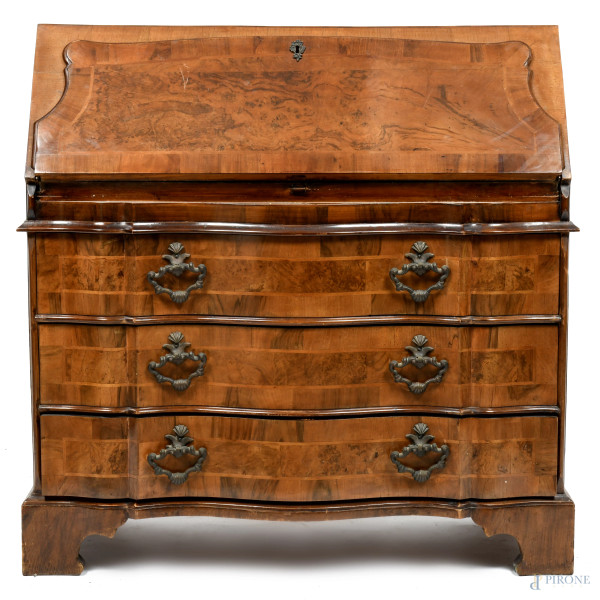 Ribaltina impiallacciata in varie essenze e decorata a pirografo con motivi floreali e stemma araldico. Fronte scandito da tre cassetti sormontati da sportello a ribalta celante vano scrittoio, XX secolo, cm 97x61x40, (segni di usura, cadute di impiallacciatura, difetti)