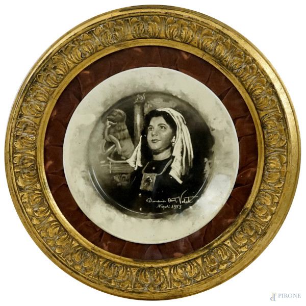Piatto in porcellana dipinta, decorato con ritratto di donna in monocromia, firmato e datato in basso a destra, diam. cm 29, entro cornice