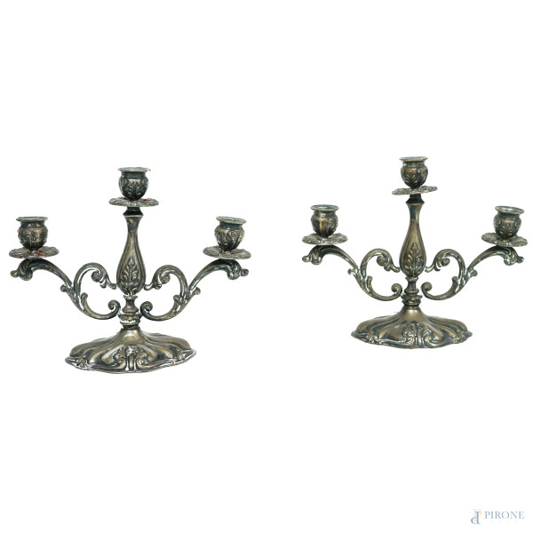 Coppia di candelabri a tre fiamme in argento con decori cesellati, Vercelli, metà XX secolo, altezza cm 18,5, peso gr. 473 (difetti)