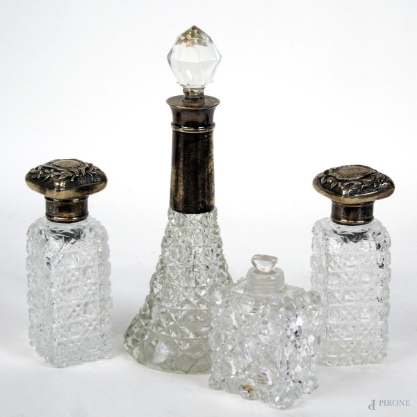 Lotto composto da quattro bottigliette portaprofumo in cristallo controtagliato, tappi in argento, alt. max cm 19, inizi XX secolo, (un tappo mancante, lievi difetti).
