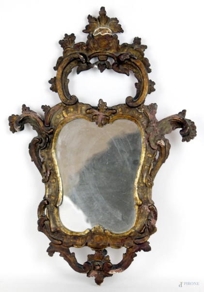 Piccola specchiera in legno intagliato e dorato, cimasa traforata decorata a volute e foglie, cm 56x38, XVIII secolo (difetti e restauri)