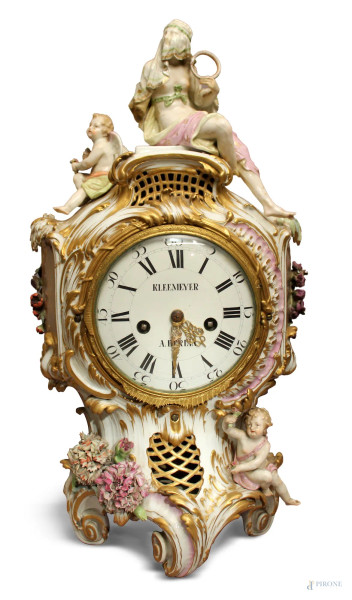 Orologio da camino in porcellana dipinta con fiori e putti a rilievo, sormontato da odalisca, XIX sec., H 62 cm, (difetti e mancanze, da revisionare).