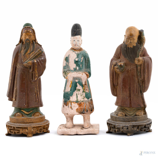 Lotto di tre sculture raffiguranti dignitari orientali in materiali vari, XX secolo, altezza massima cm 27,5, (segni di usura, difetti, consunzioni, abrasioni, scalfiture, mancanze, rotture, difetti)